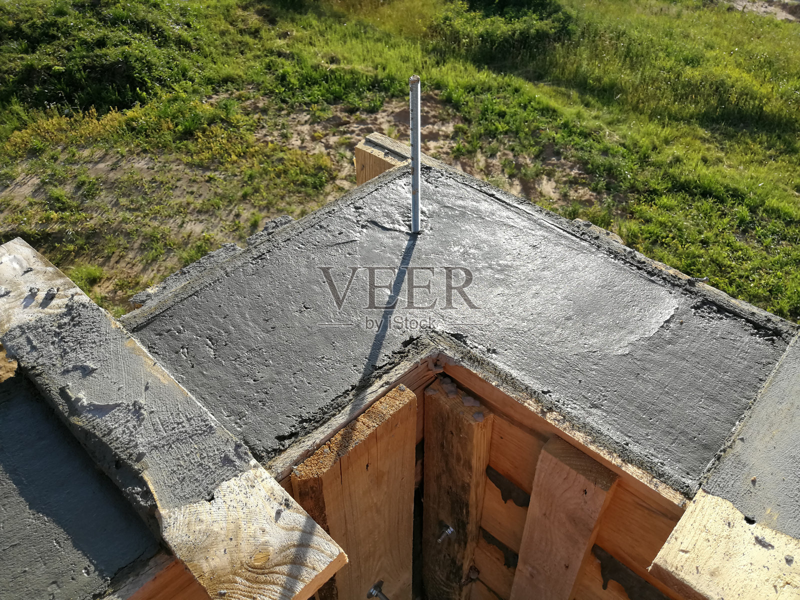 在建筑工地,金属螺丝插入湿混凝土中照片摄影图片