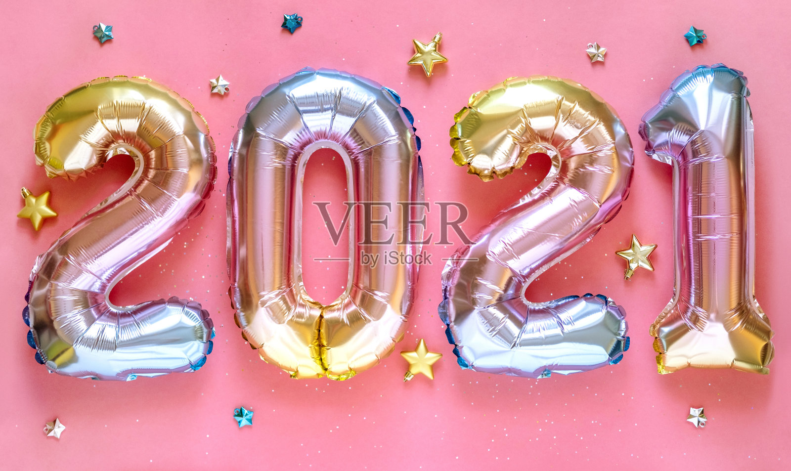 庆祝2021年新年。气球铝箔数字2021和亮星在粉红色的背景。平躺照片摄影图片