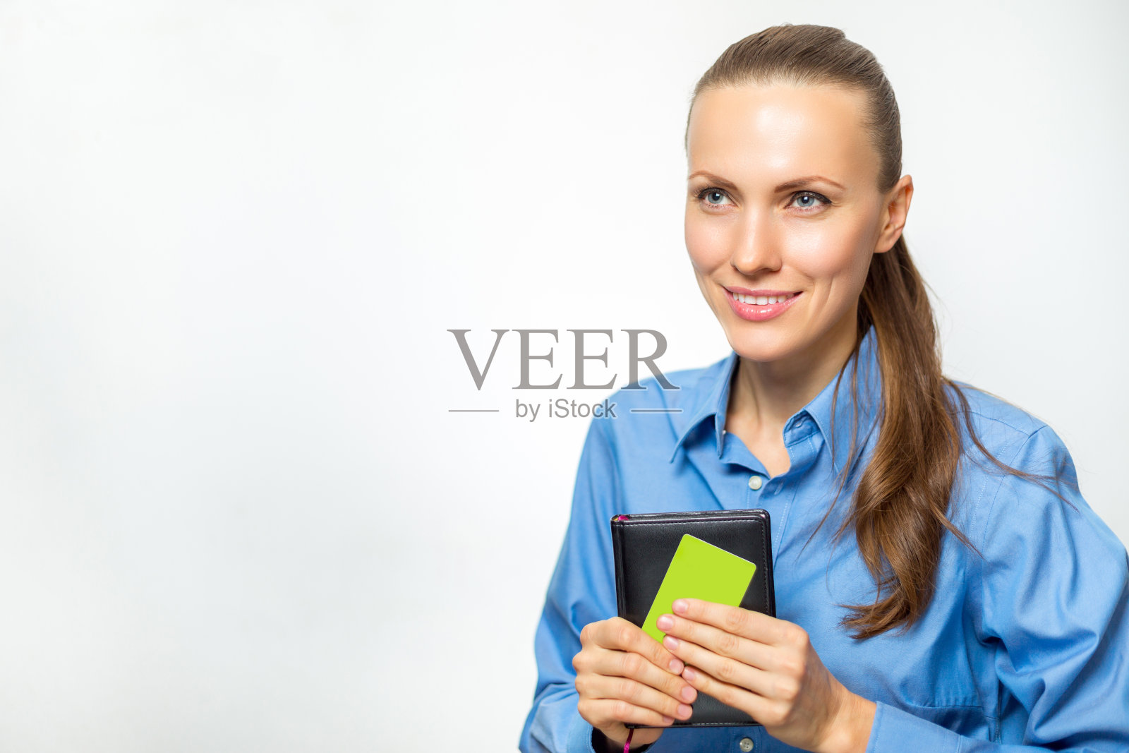 年轻漂亮的女人穿着正式的衣服,手里拿着一张空白的卡片孤立在白色之上照片摄影图片