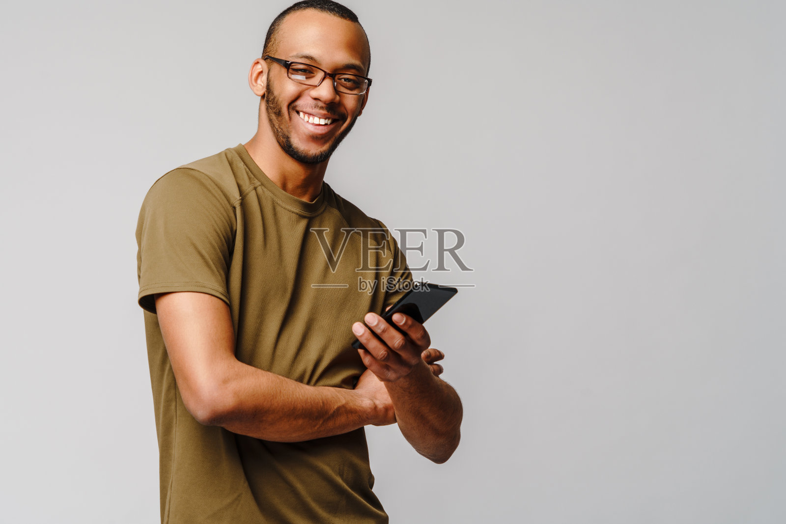 一个年轻的非洲裔美国人戴着眼镜拿着手机的肖像照片摄影图片