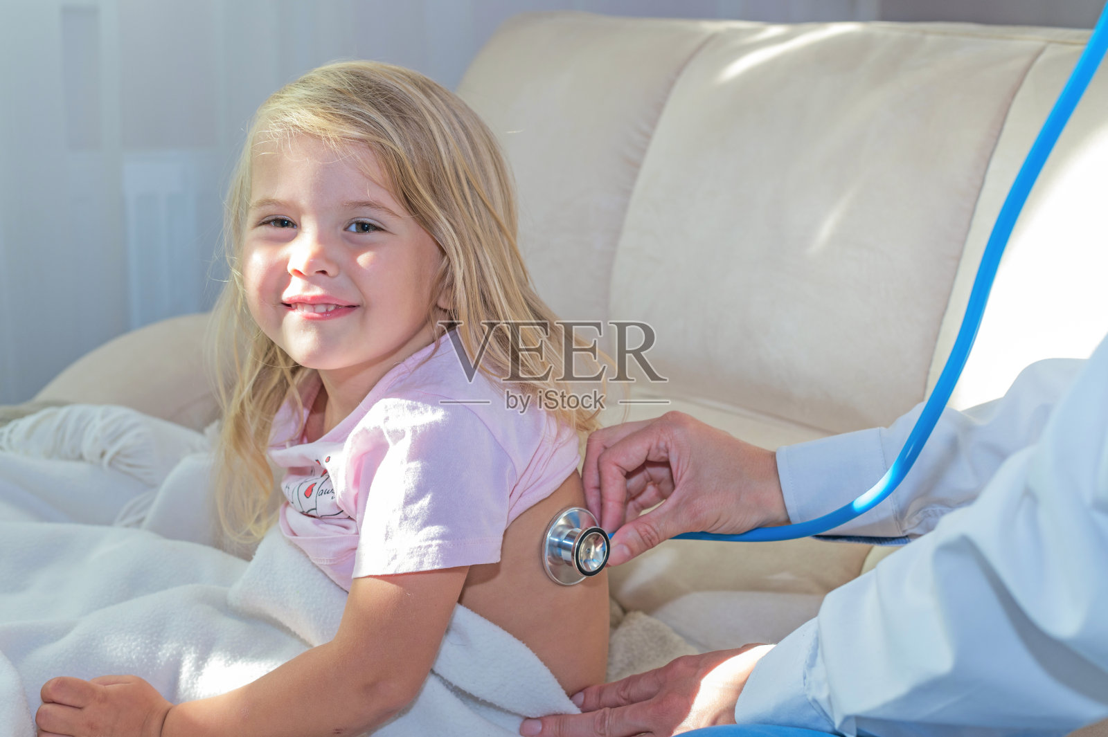 小儿科医生用听诊器检查小女孩。照片摄影图片