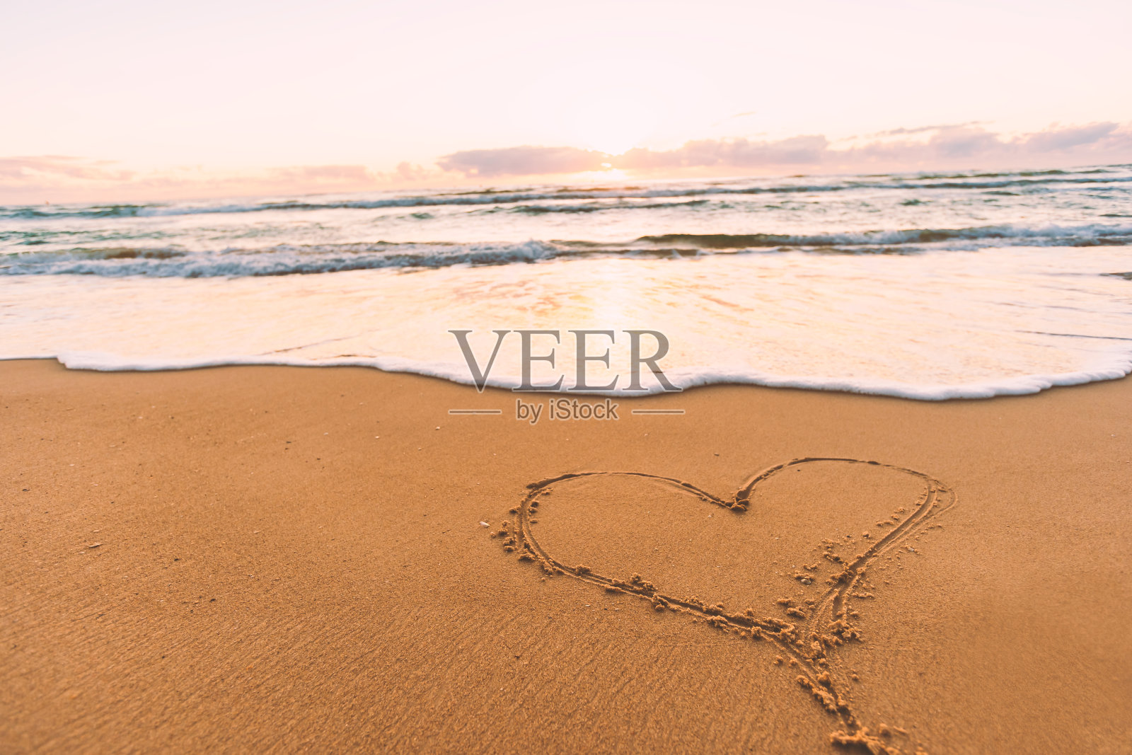 沙滩上手写的心形图案,日出日落时分的海岸与海洋照片摄影图片