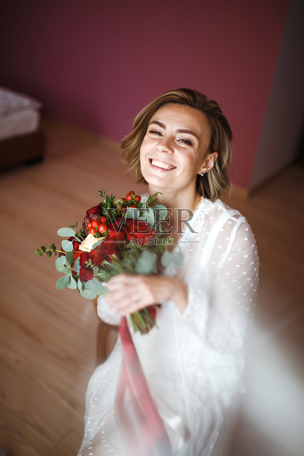 美丽的新娘与婚礼鲜花花束在白色豪华礼服准备婚礼。照片摄影图片