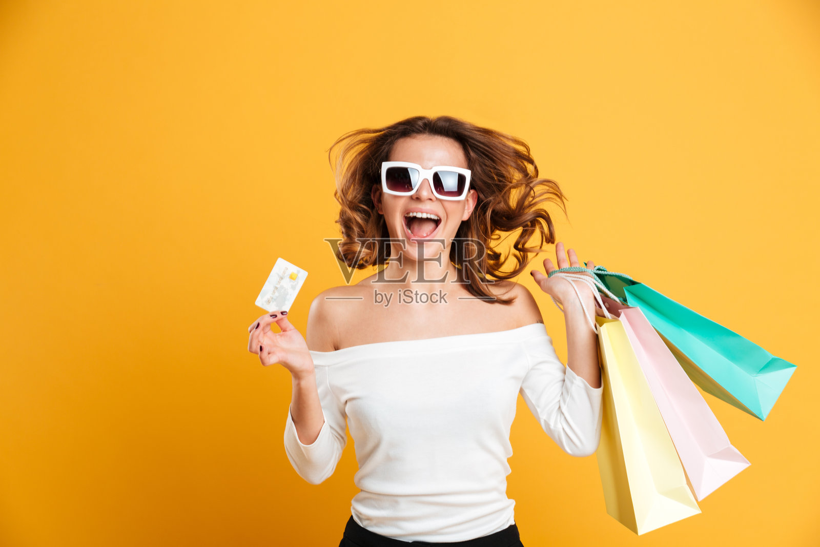 兴高采烈的年轻女子拿着购物袋照片摄影图片