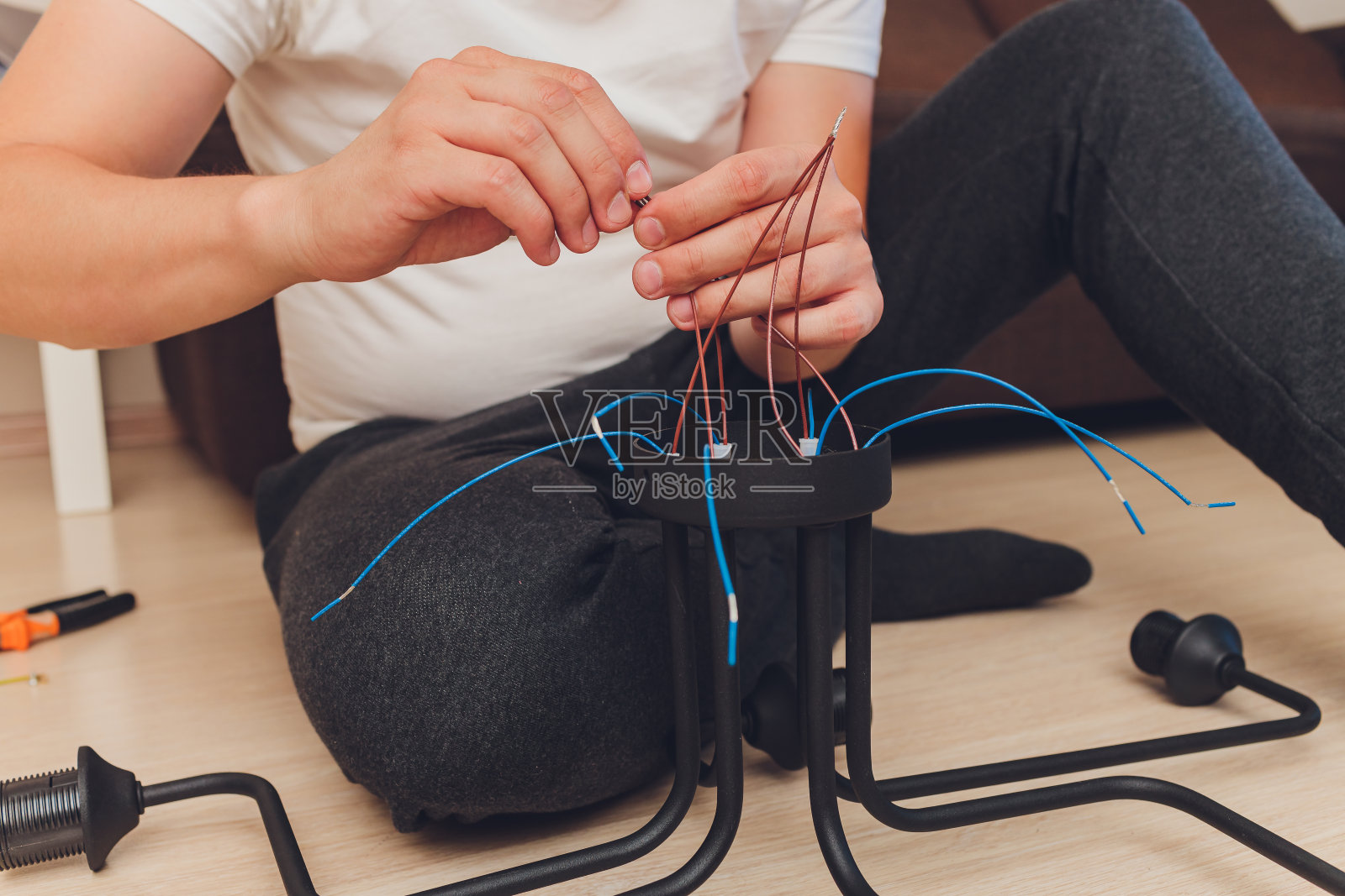 吊灯与电线和工具放在地板上,准备安装。照片摄影图片