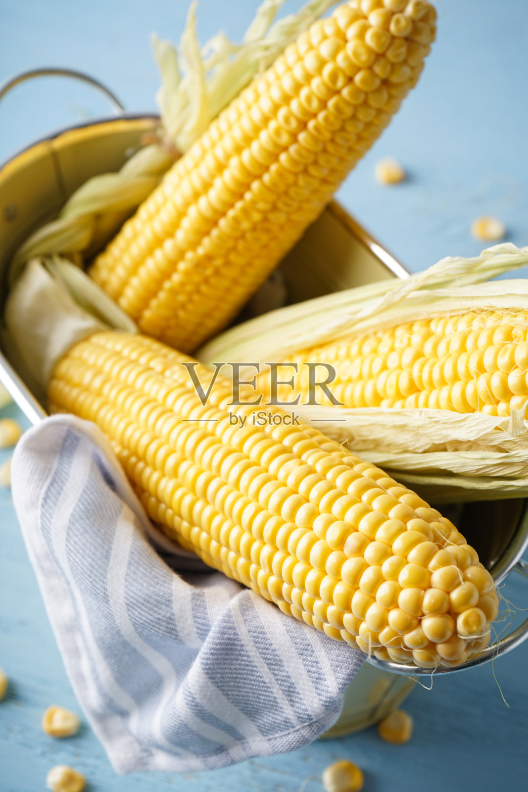 蓝色木质背景篮子里的成熟生玉米棒特写照片摄影图片