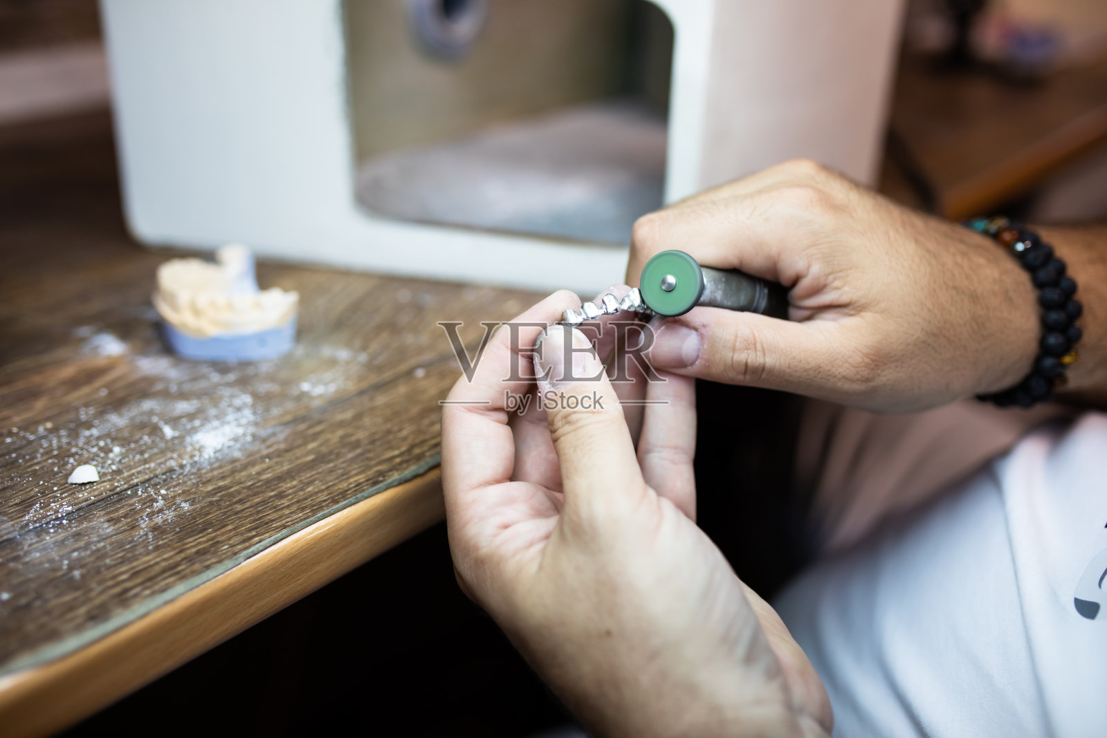 牙齿修复医师在修整假牙照片摄影图片