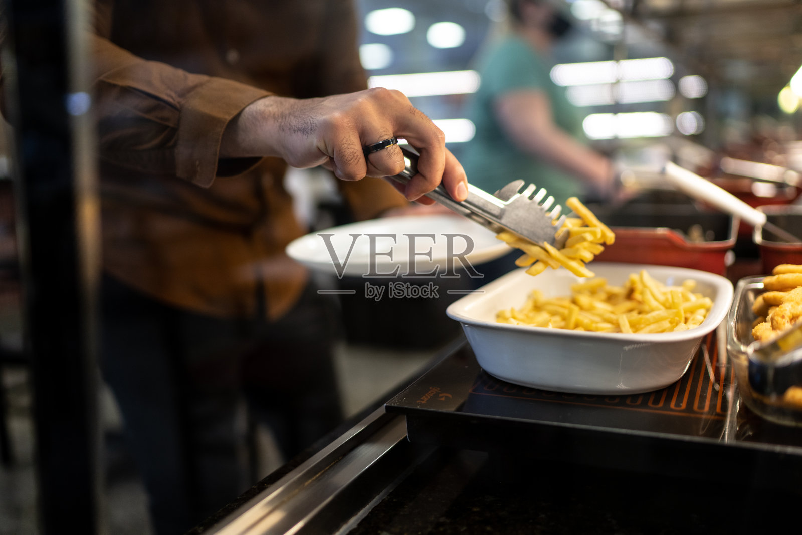 一个在自助自助餐厅选择食物的男人裁剪的手照片摄影图片