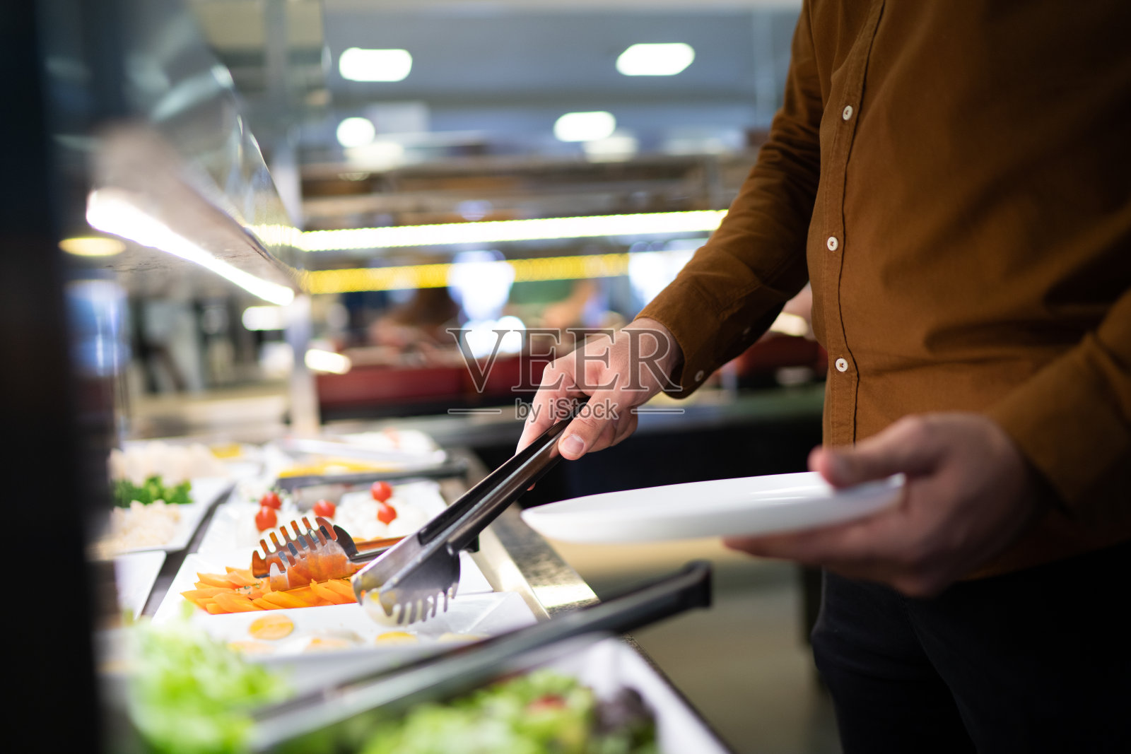 一个在自助自助餐厅选择食物的男人裁剪的手照片摄影图片