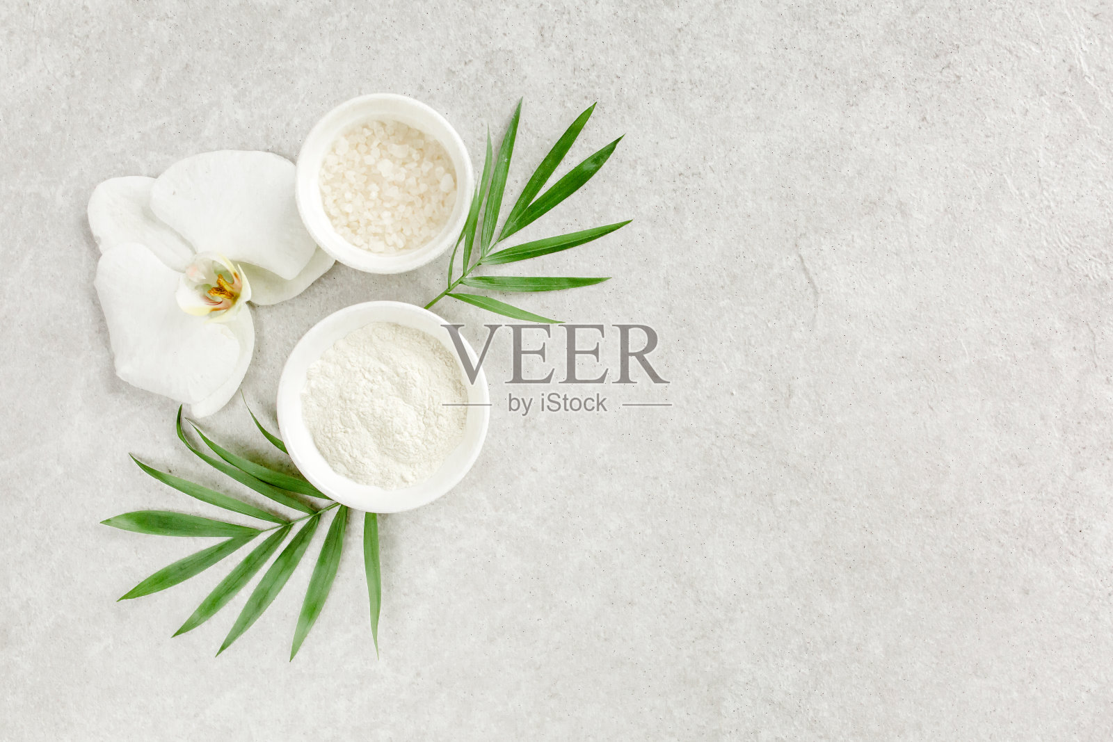 矿泉疗法的概念。天然有机水疗化妆品,海盐,热带棕榈叶从上面灰色大理石桌子。水疗中心的背景照片摄影图片