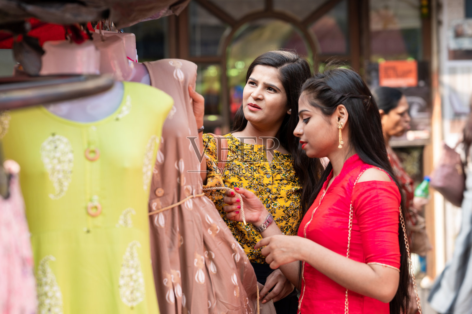 女孩们在街头市场买衣服照片摄影图片