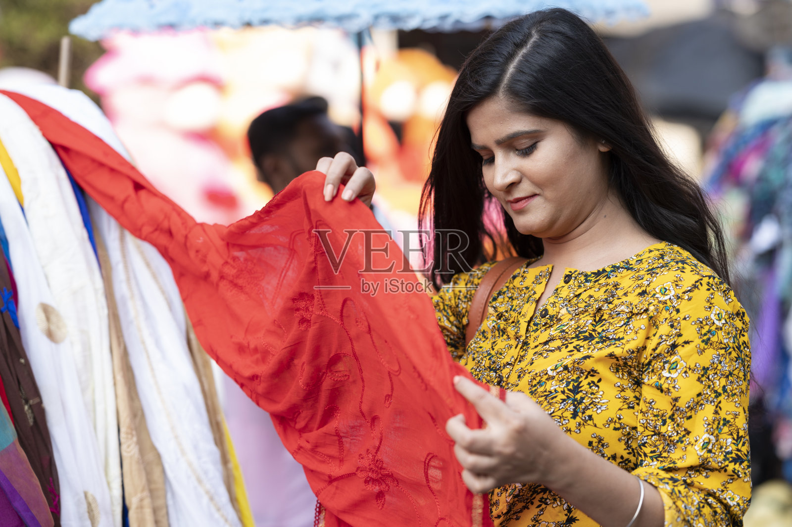 在街头市场买衣服的女人照片摄影图片