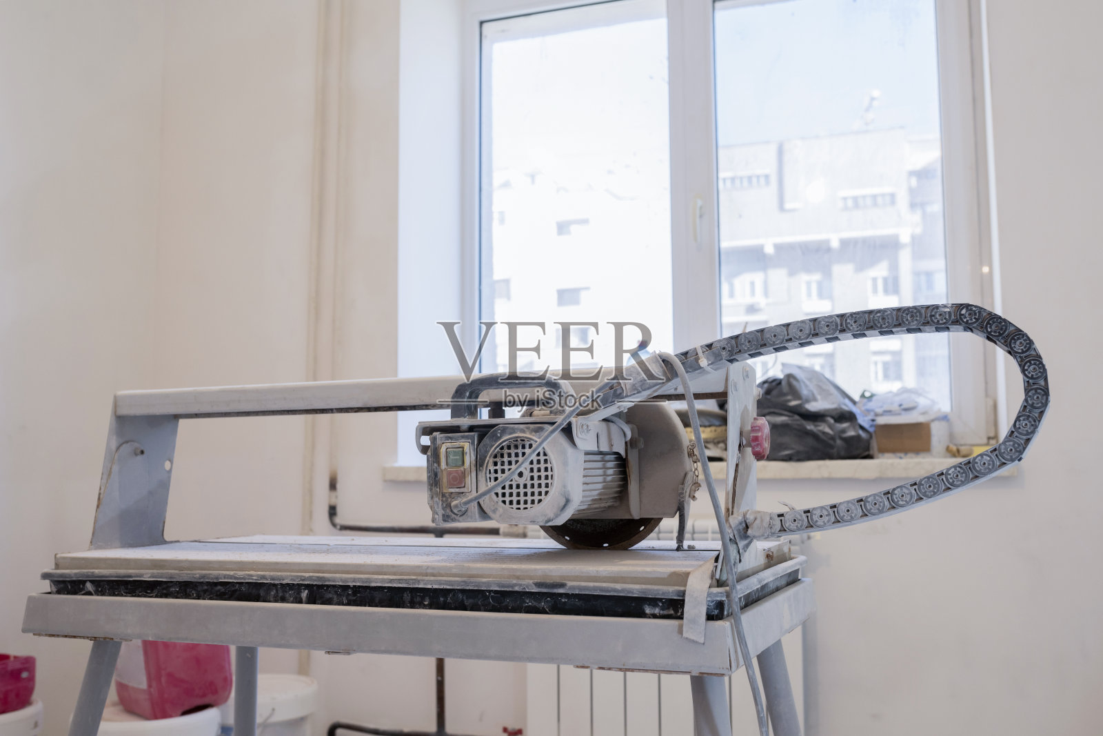 切割瓦片的工具,空房间里的瓦片。修理和拆除公寓。照片摄影图片