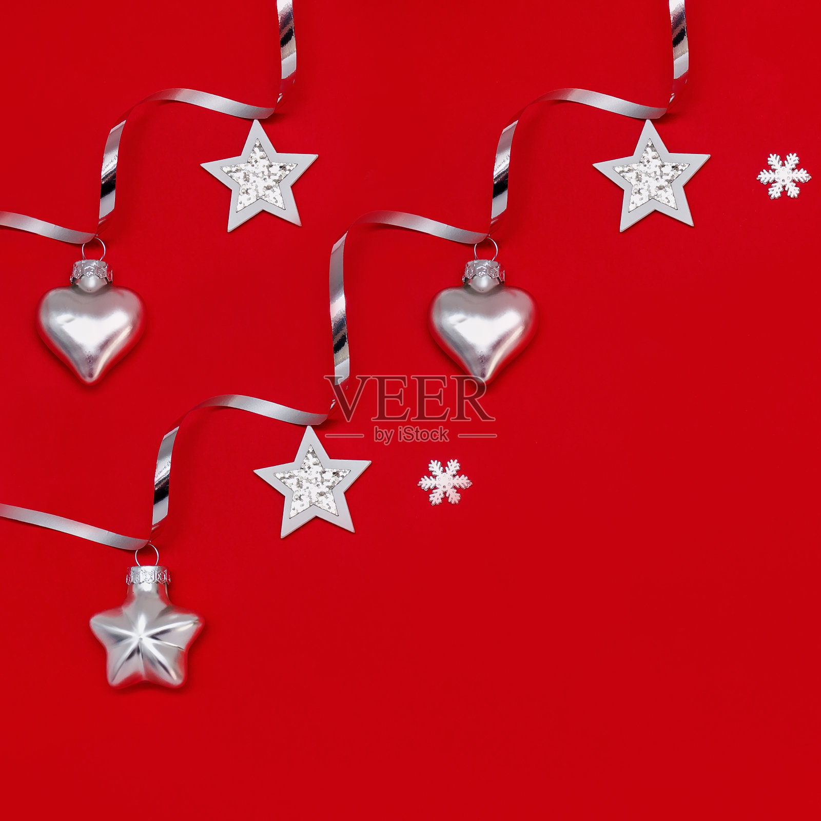 以红色为背景的银色圣诞装饰品的平面构图。照片摄影图片