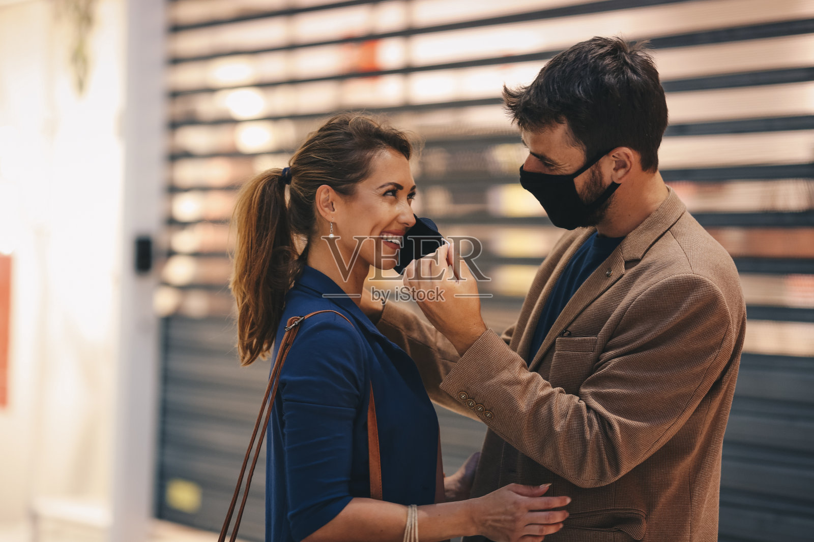 一对年轻夫妇去购物,他戴着口罩,她也戴着口罩,在疫情期间购物照片摄影图片