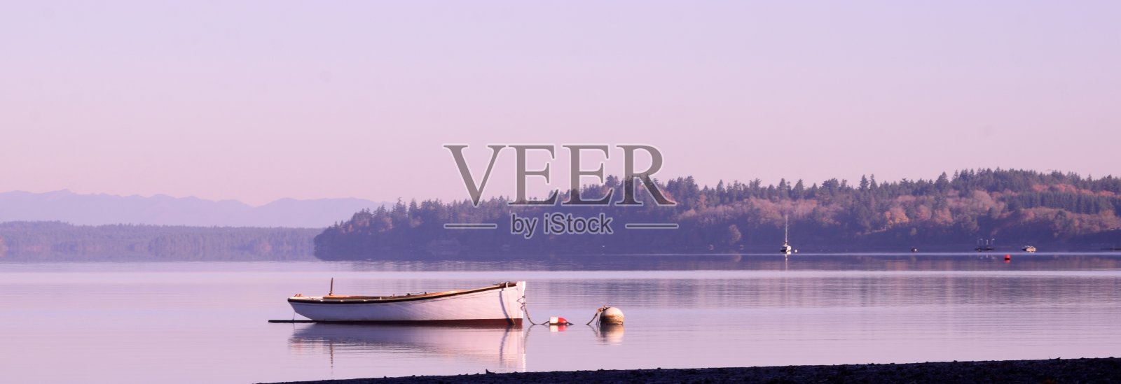 在平静的秋天日出时在海湾抛锚的船照片摄影图片