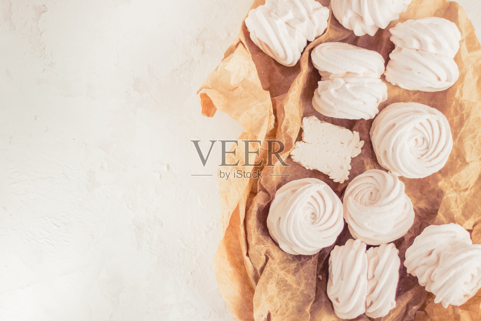 自制的俄罗斯和风由苹果、覆盆子和黑莓在白色混凝土背景孤立。免费空间。白色棉花糖在棕色的米色纸上照片摄影图片