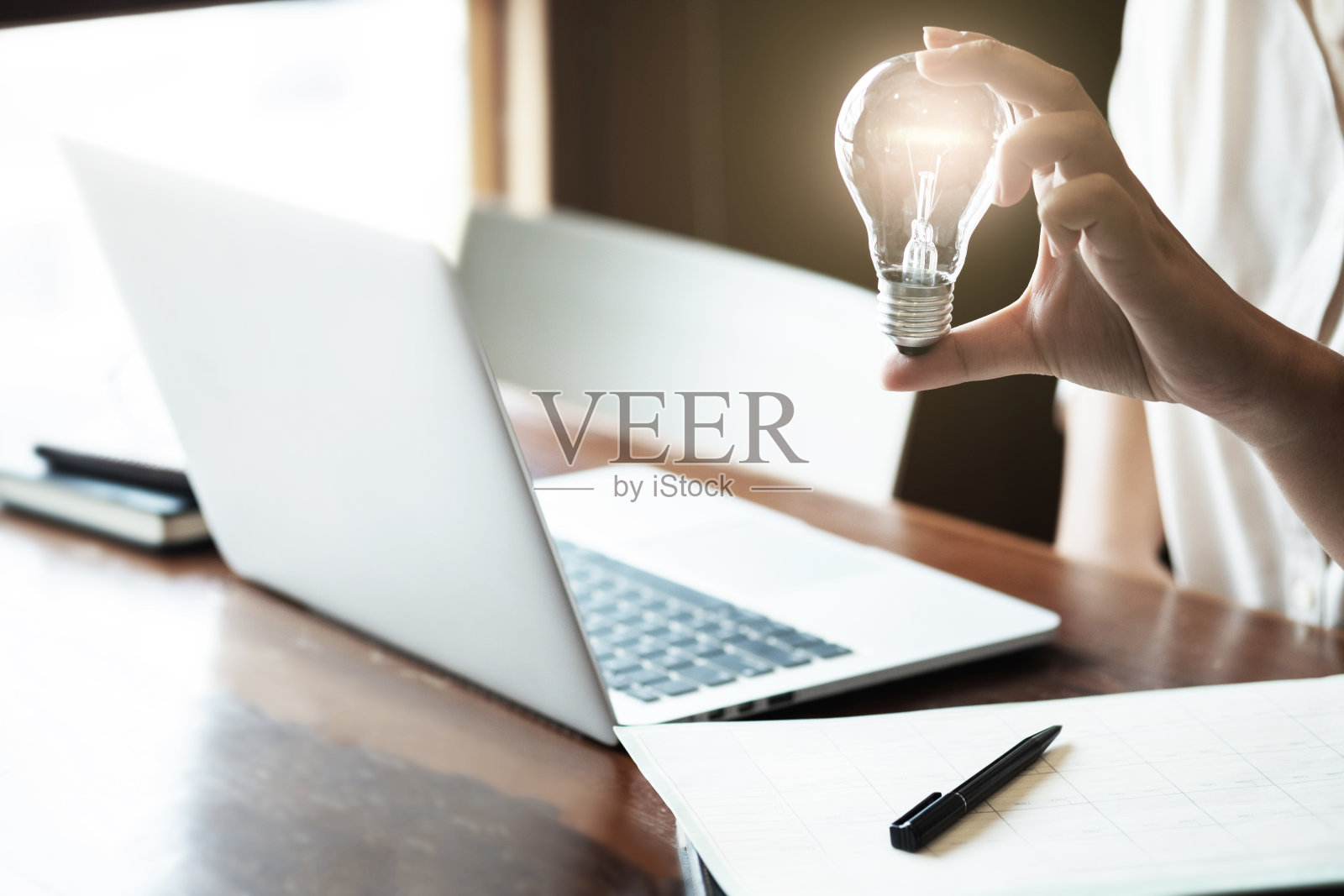 点子和灵感概念,女人拿着灯泡思考一个新项目。照片摄影图片