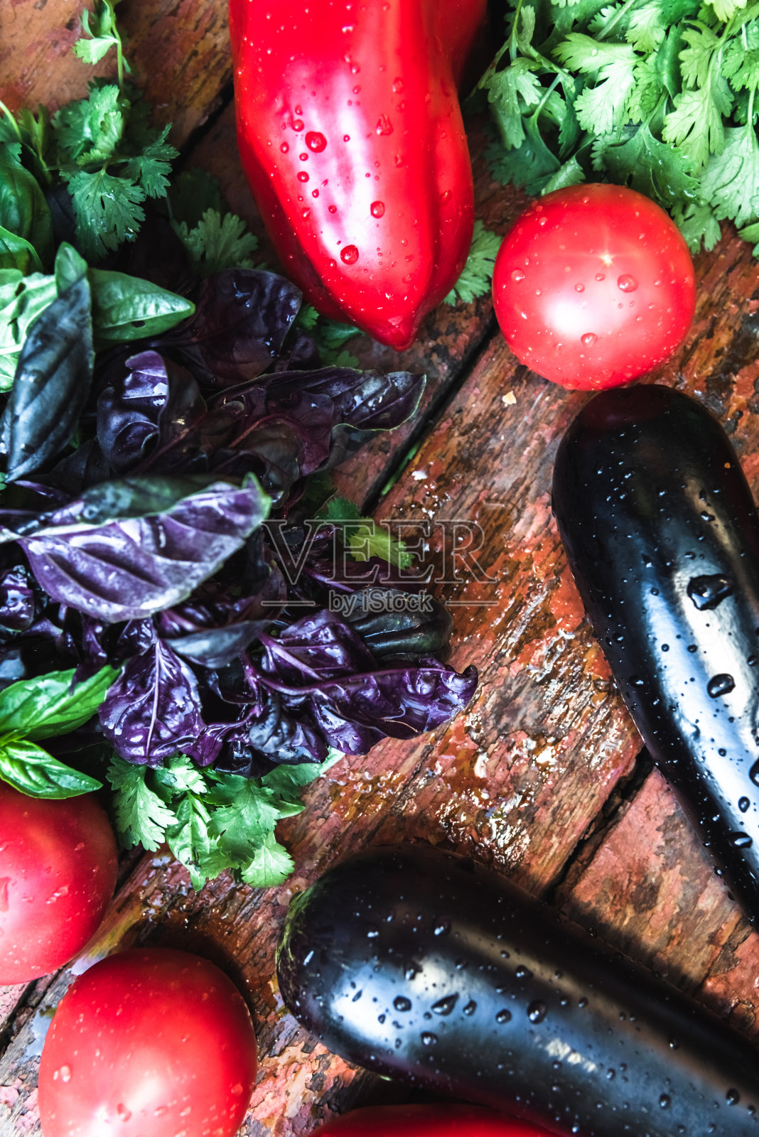 农场里的西红柿、茄子和绿色植物躺在一个木制的表面上。生物概念、生物产品、生物生态、自产、素食照片摄影图片