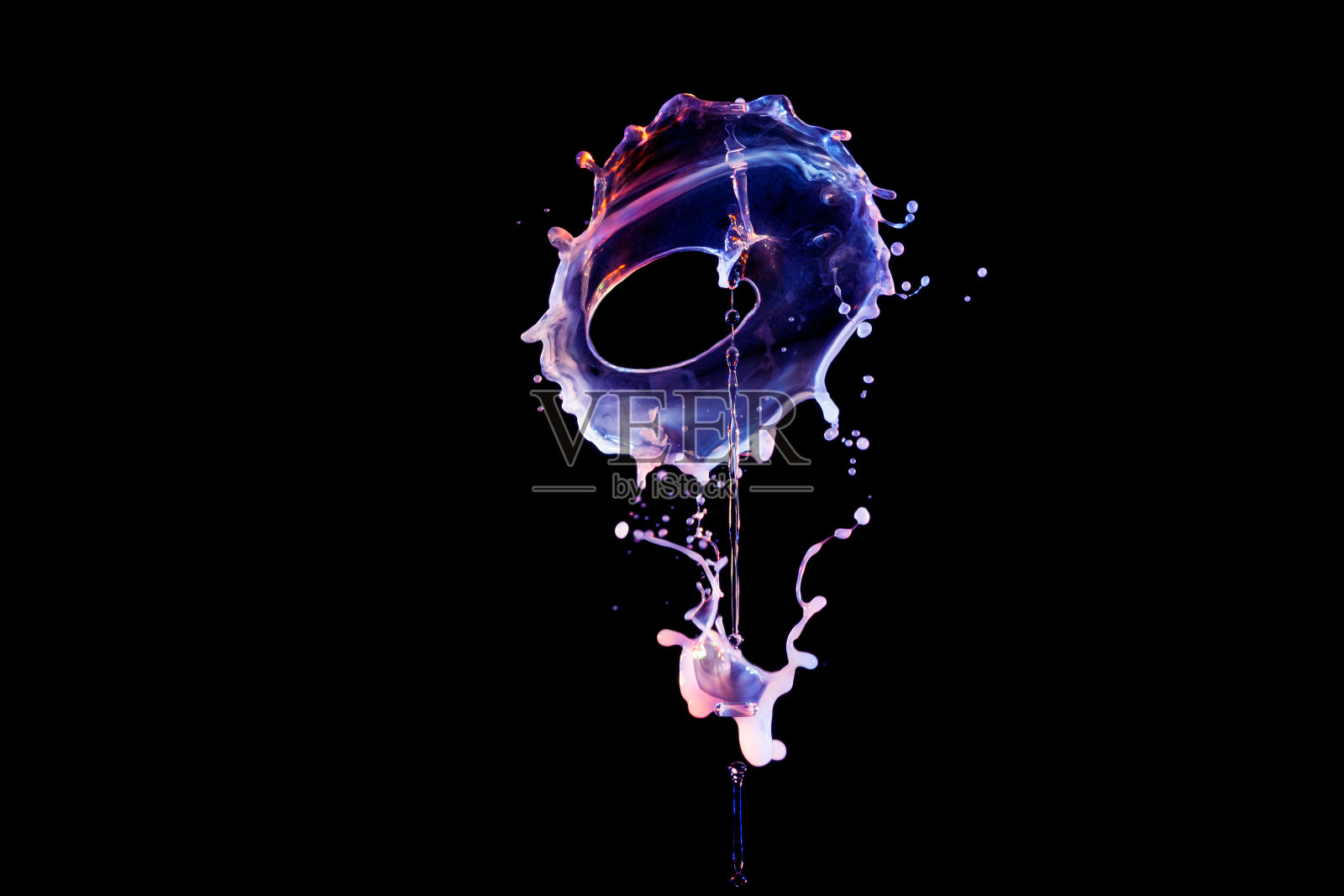 彩色的液体滴落在黑色的背景上照片摄影图片