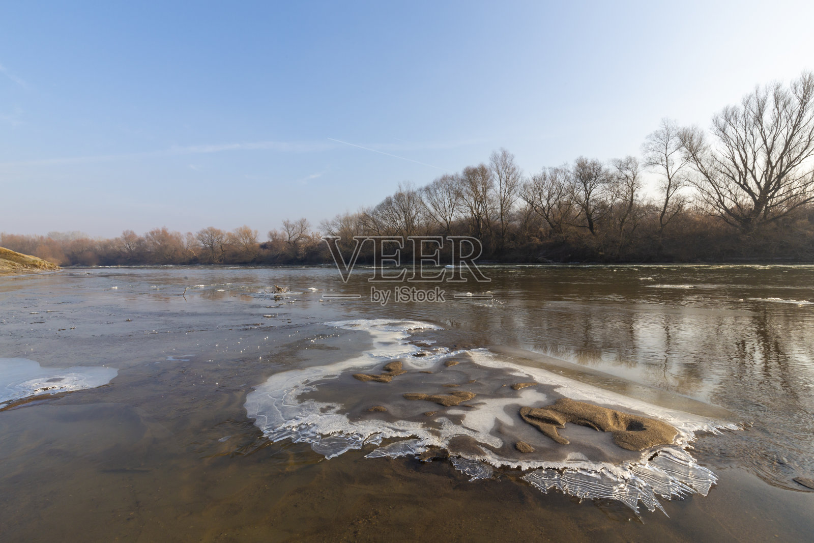 美丽的沙丘覆盖着霜和新雪,在一个荒凉的河岸上,在冬天照片摄影图片