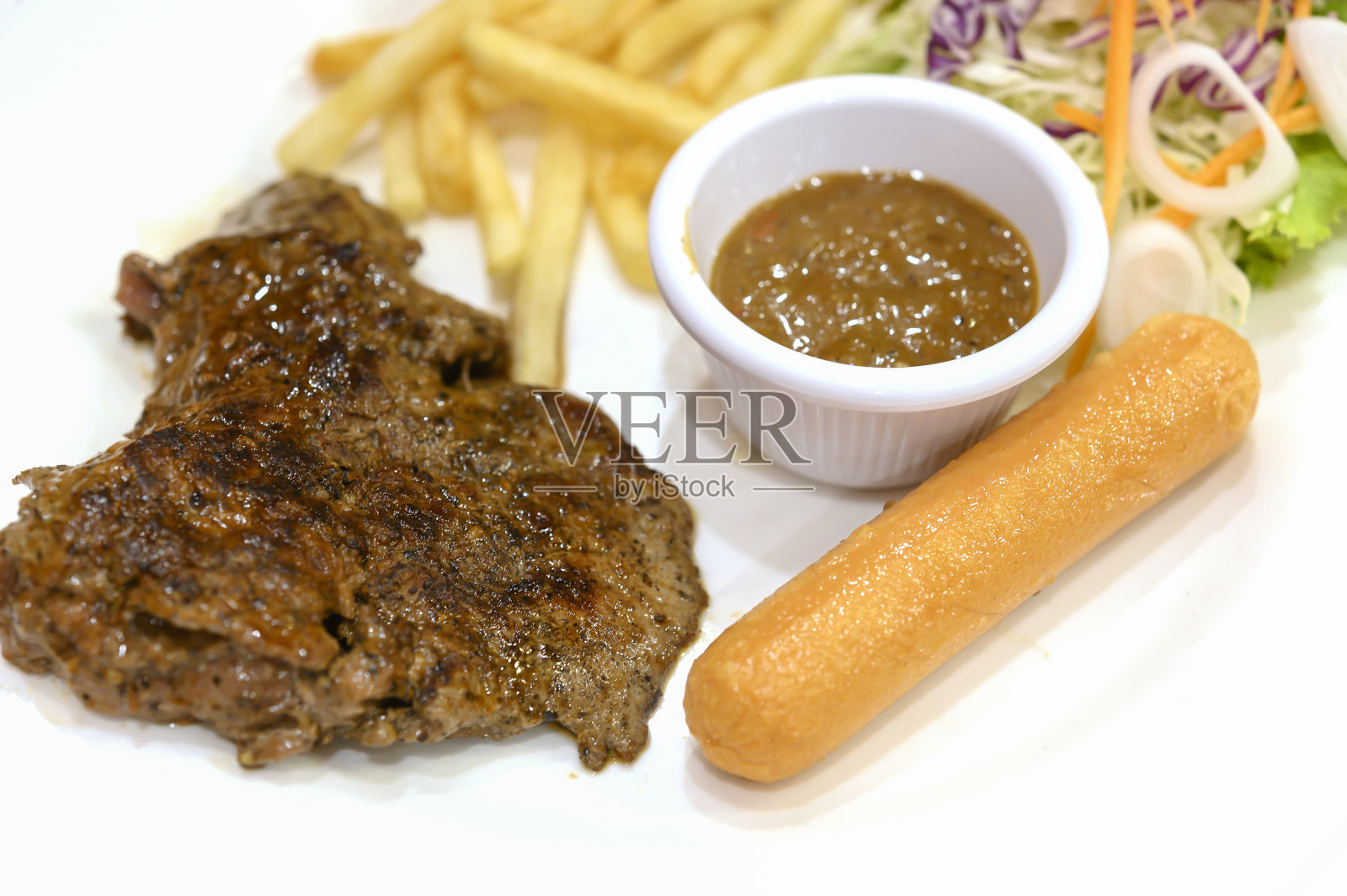 黑椒肉排配薯条和香肠照片摄影图片