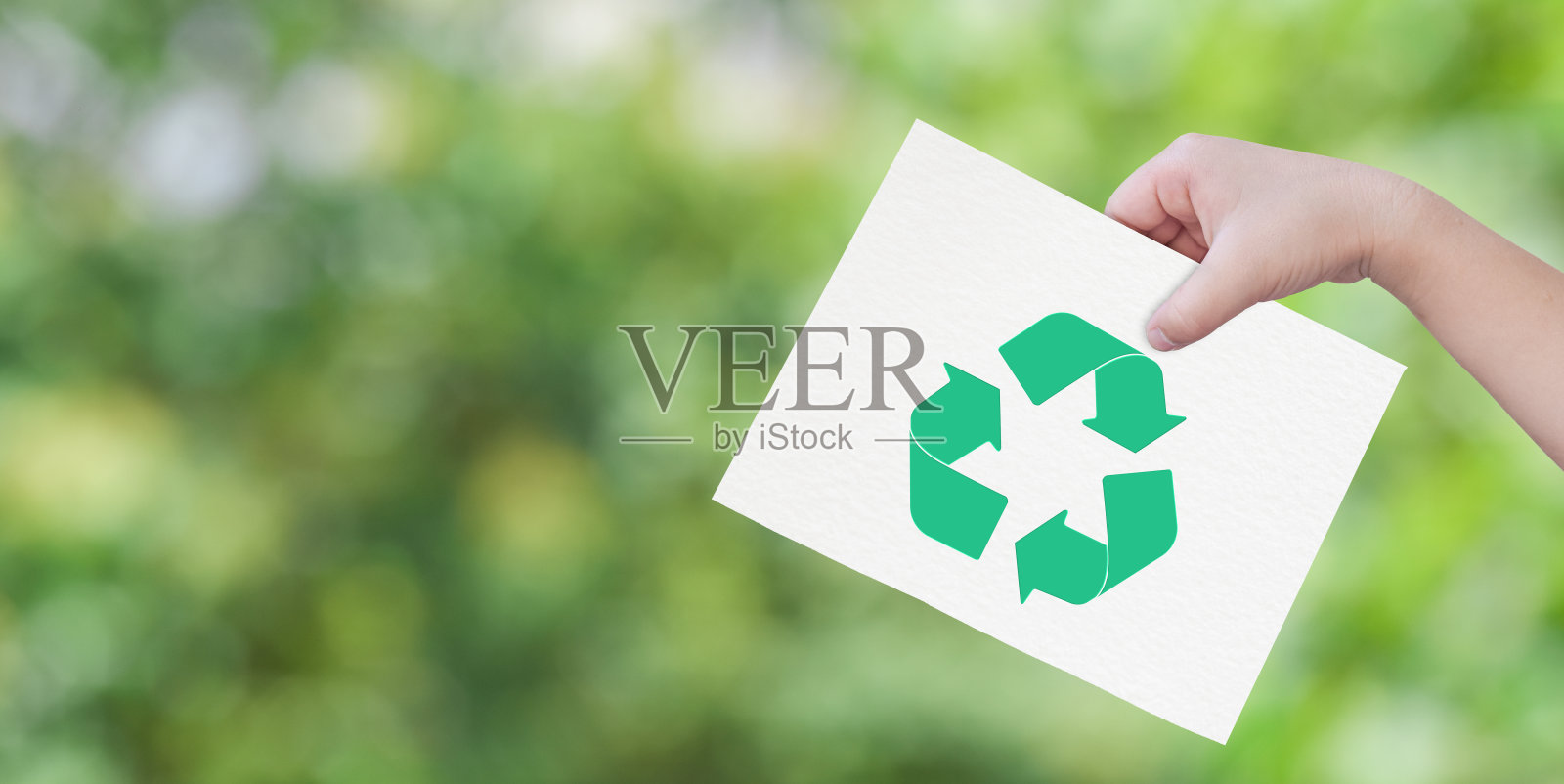 儿童手握剪纸与标志回收在绿色背景。照片摄影图片