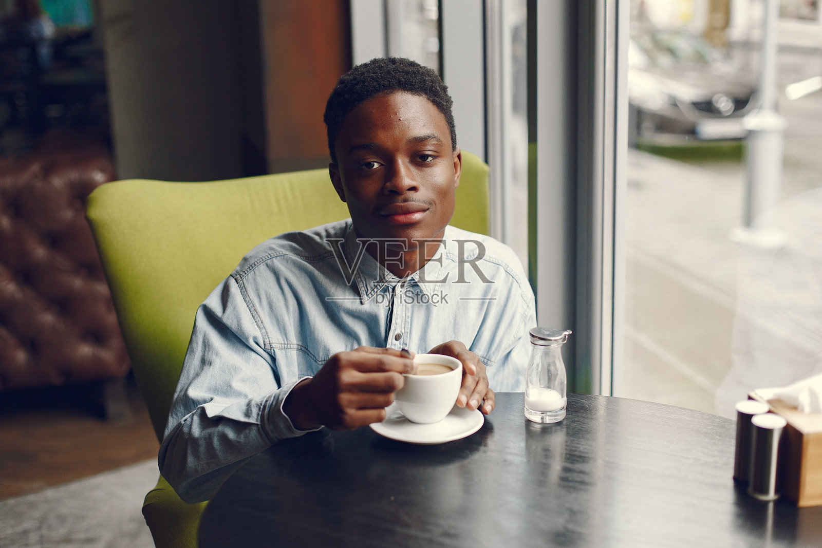 一个坐在咖啡馆里喝咖啡的黑人照片摄影图片