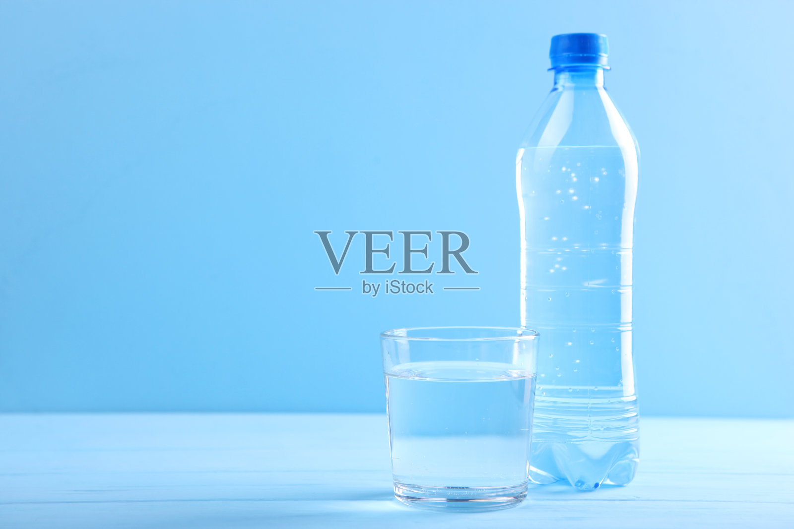 桌上有玻璃杯和瓶子,里面装着清水照片摄影图片