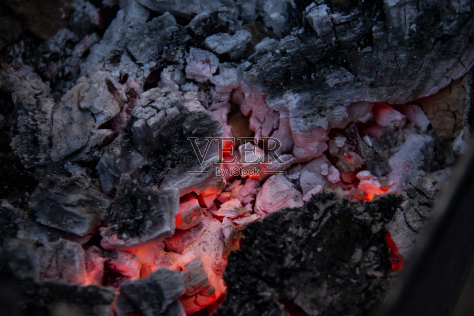 燃烧煤。木炭腐烂的特写,烧烤季节。火焰的闪光。在夜晚燃烧着炽热的煤和木头。红色的煤在篝火中燃烧。照片摄影图片