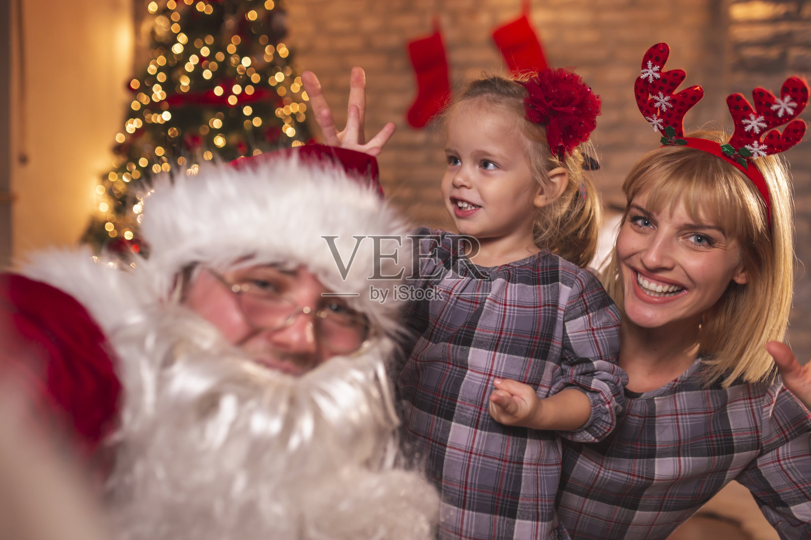 母女俩在和圣诞老人自拍照片摄影图片