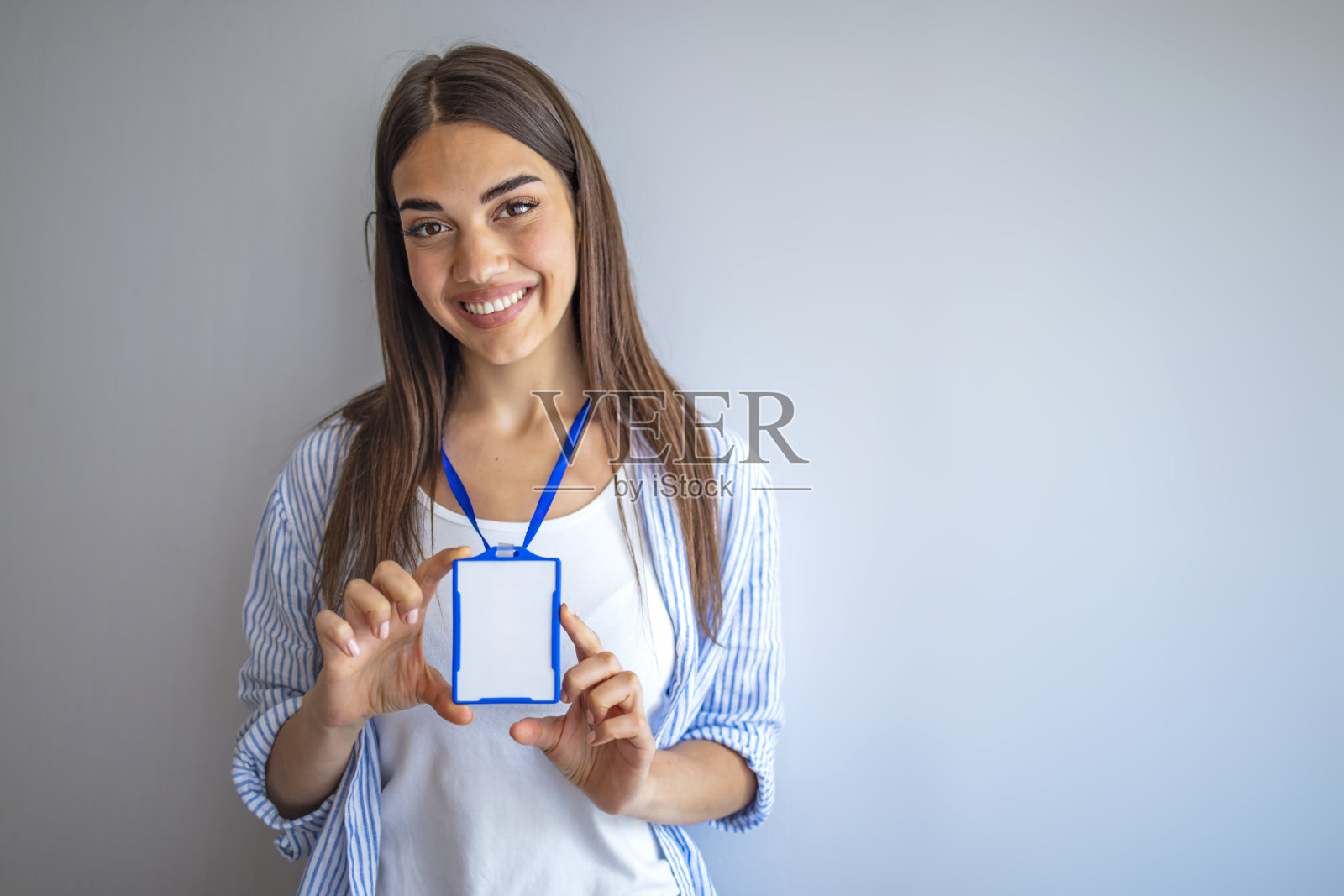 女人拿着身份证白色空白塑料身份证。照片摄影图片