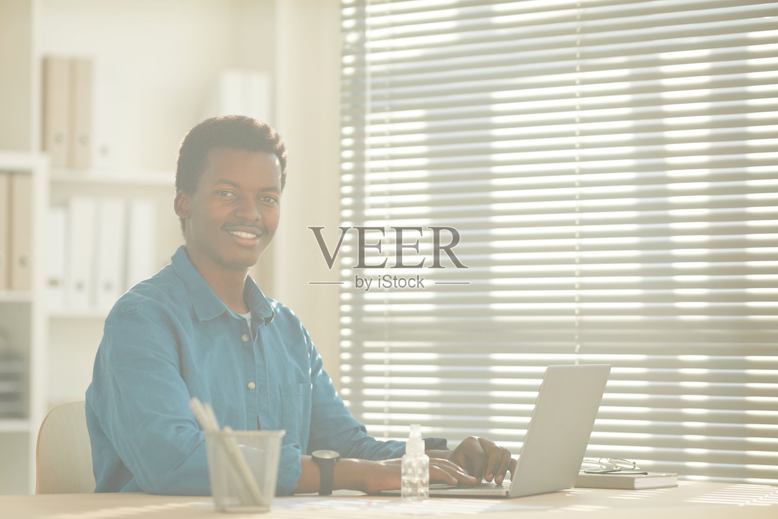 微笑的非洲人在阳光照耀下的办公室工作照片摄影图片