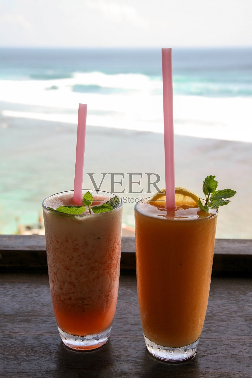 两杯以印度洋为背景的水果鸡尾酒吸管照片摄影图片