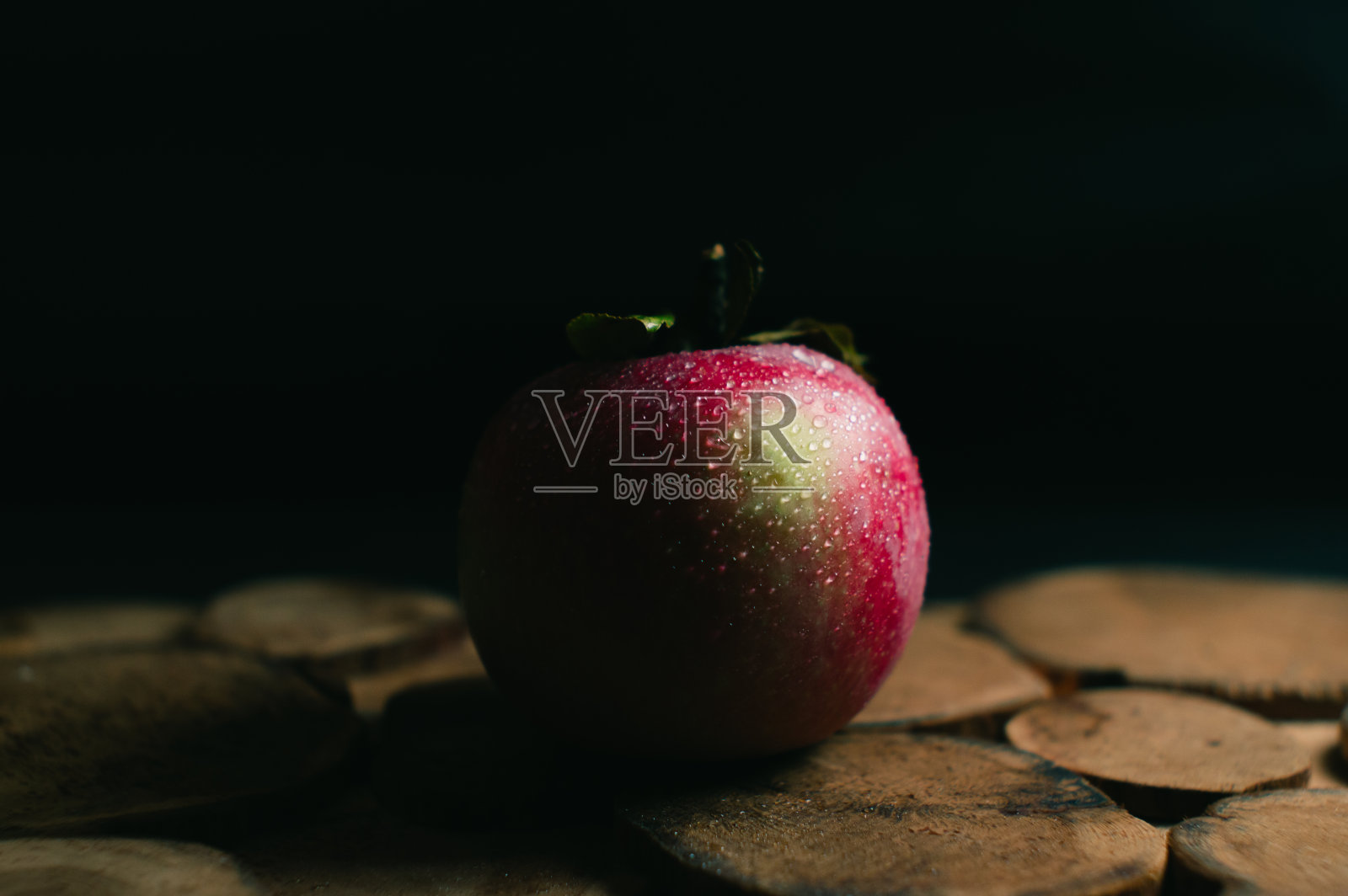 黑色背景上有小枝的红苹果照片摄影图片