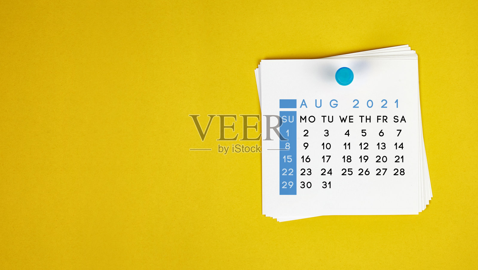 2021年8月的日历钉在黄色背景上。照片摄影图片