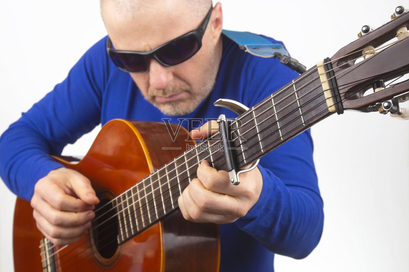 男子在白色背景下弹奏古典吉他。音乐创造力。弦的乐器照片摄影图片