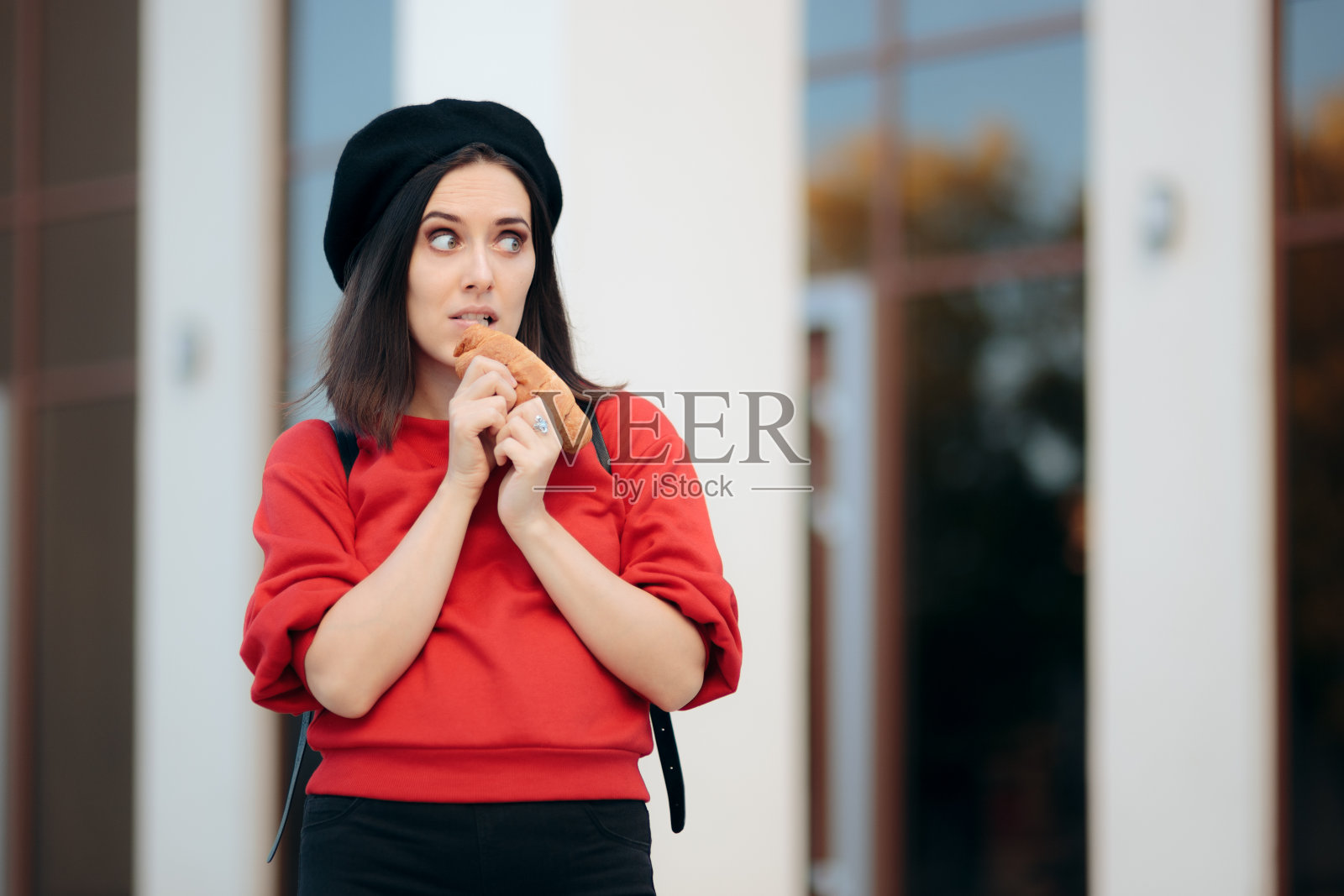 有趣的女游客在户外吃羊角面包照片摄影图片