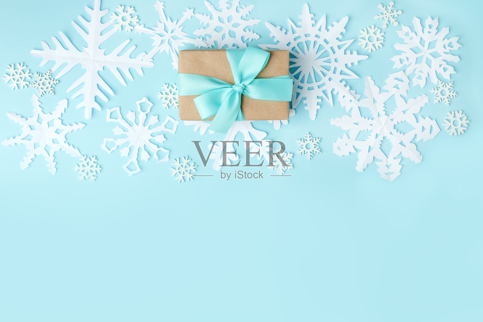 礼物或礼物盒和白色装饰木和纸工艺雪花在蓝色的背景,简单的最小的冬季假日背景,圣诞新年2021概念,拷贝空间,周年贺卡照片摄影图片