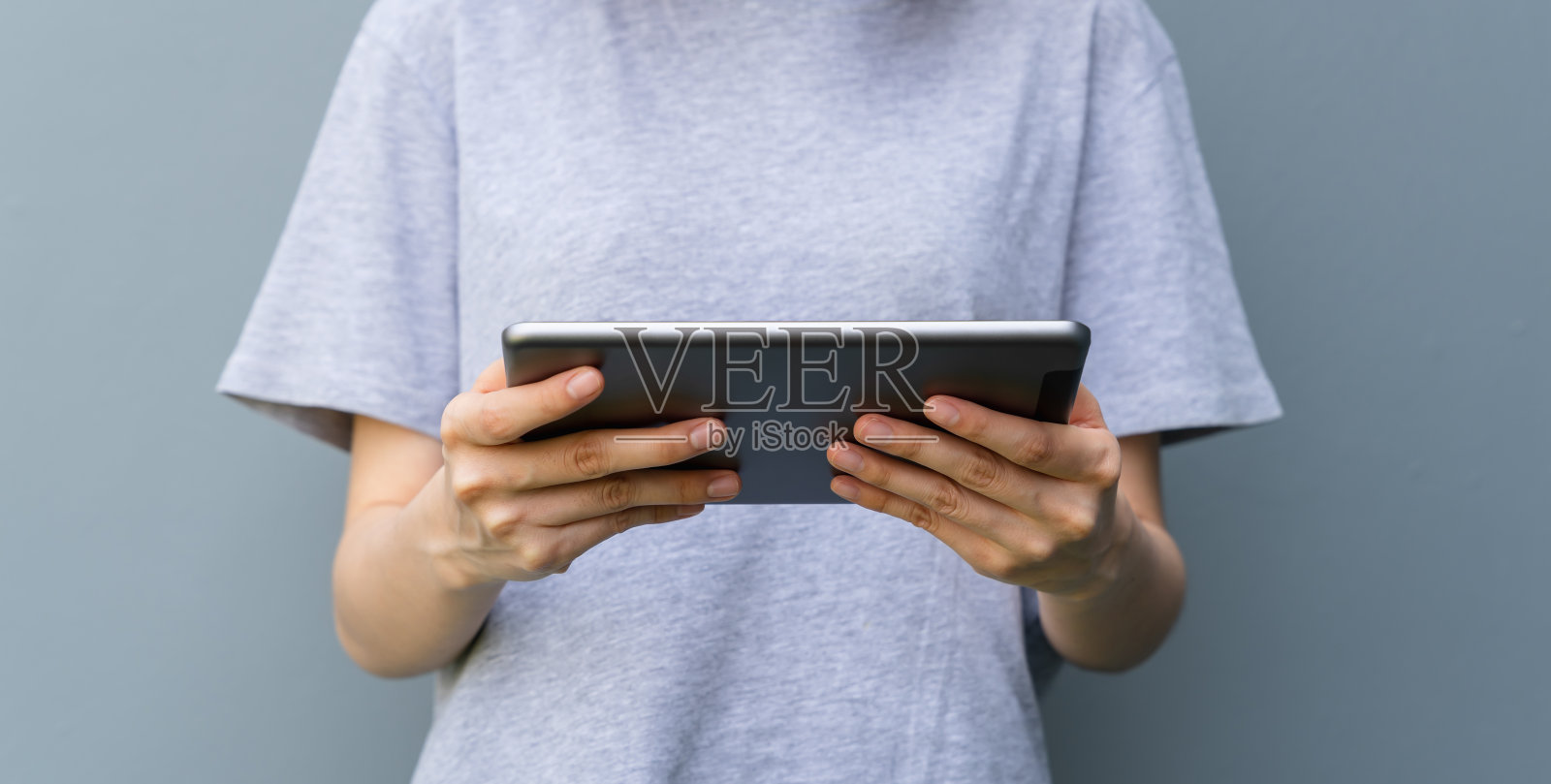 年轻女子手持数码平板电脑的特写。照片摄影图片