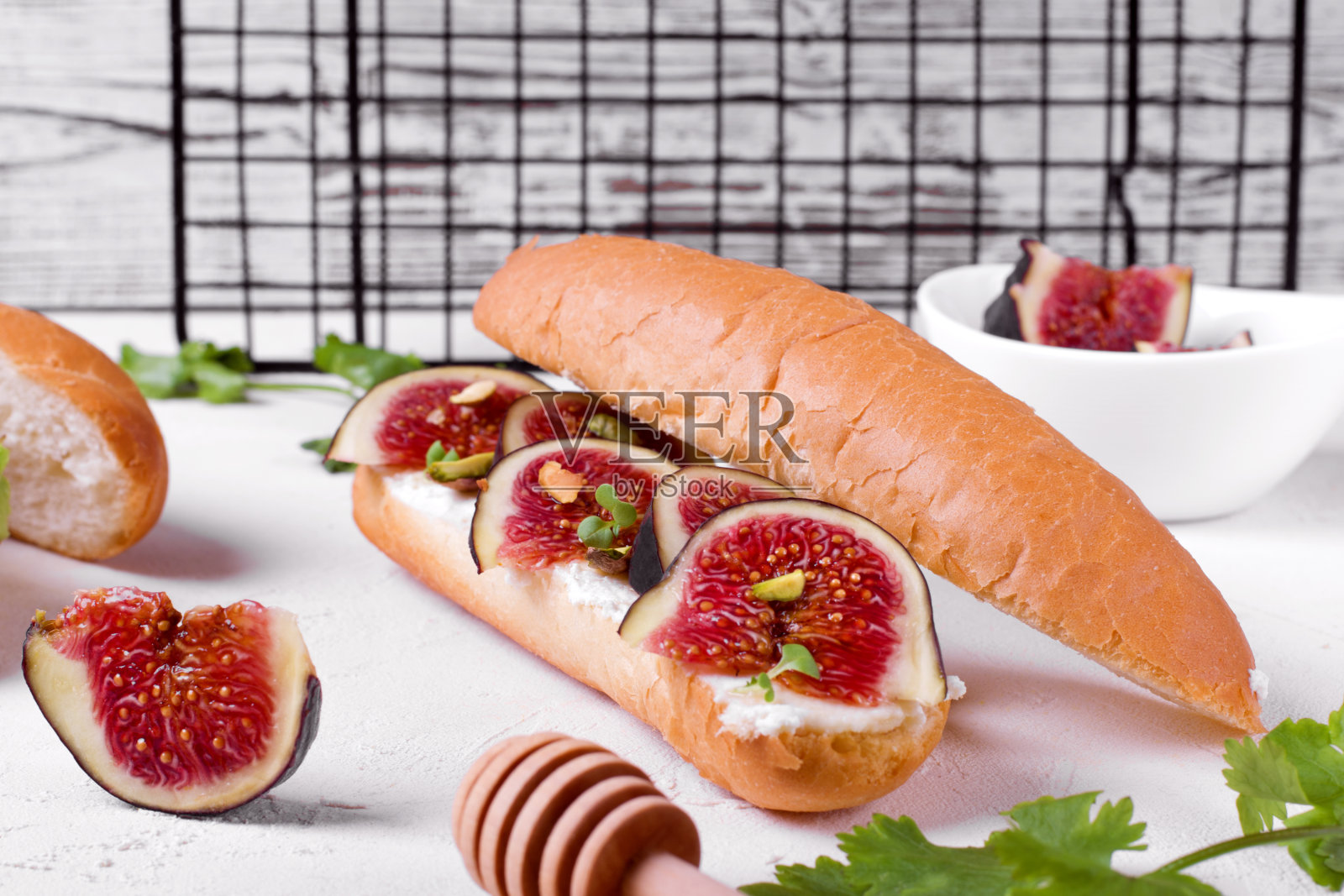 夹无花果、奶油芝士、开心果、微绿和蜂蜜的三明治照片摄影图片