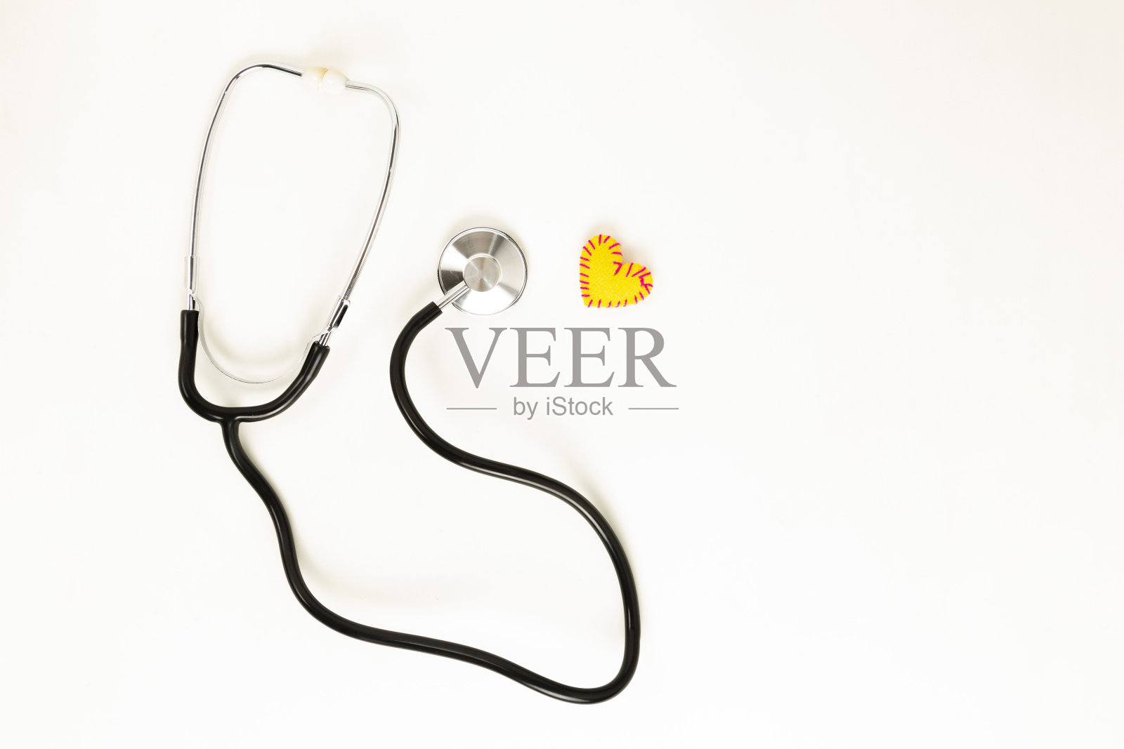 心脏健康和预防的概念。听诊器和红心钩针在白色孤立的背景与文字空间。照片摄影图片