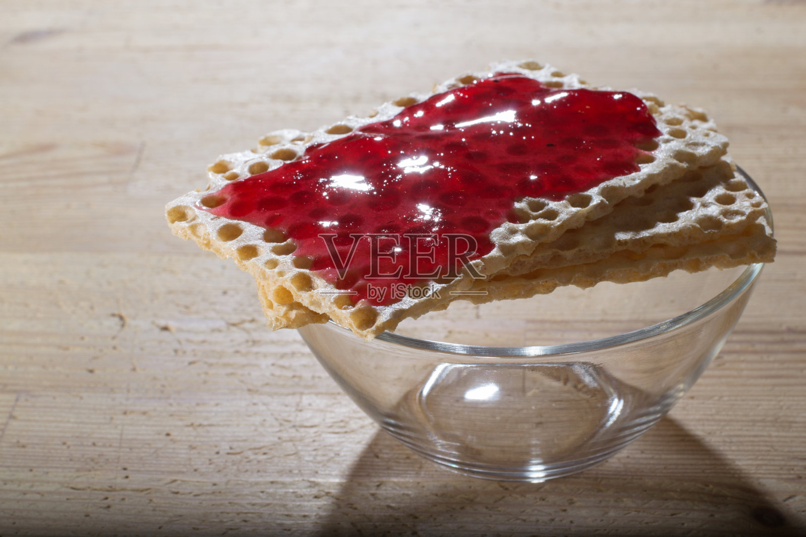 玻璃碗上盖着果酱的脆饼照片摄影图片