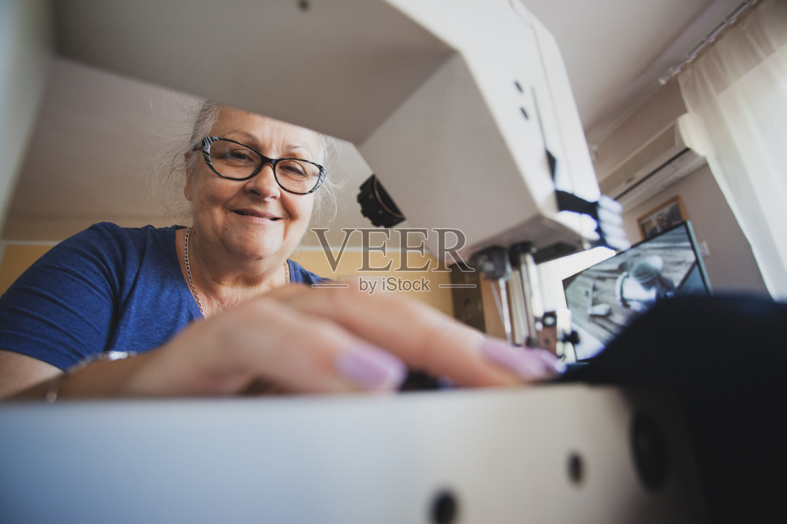 裁缝成熟的女人在家缝制照片摄影图片