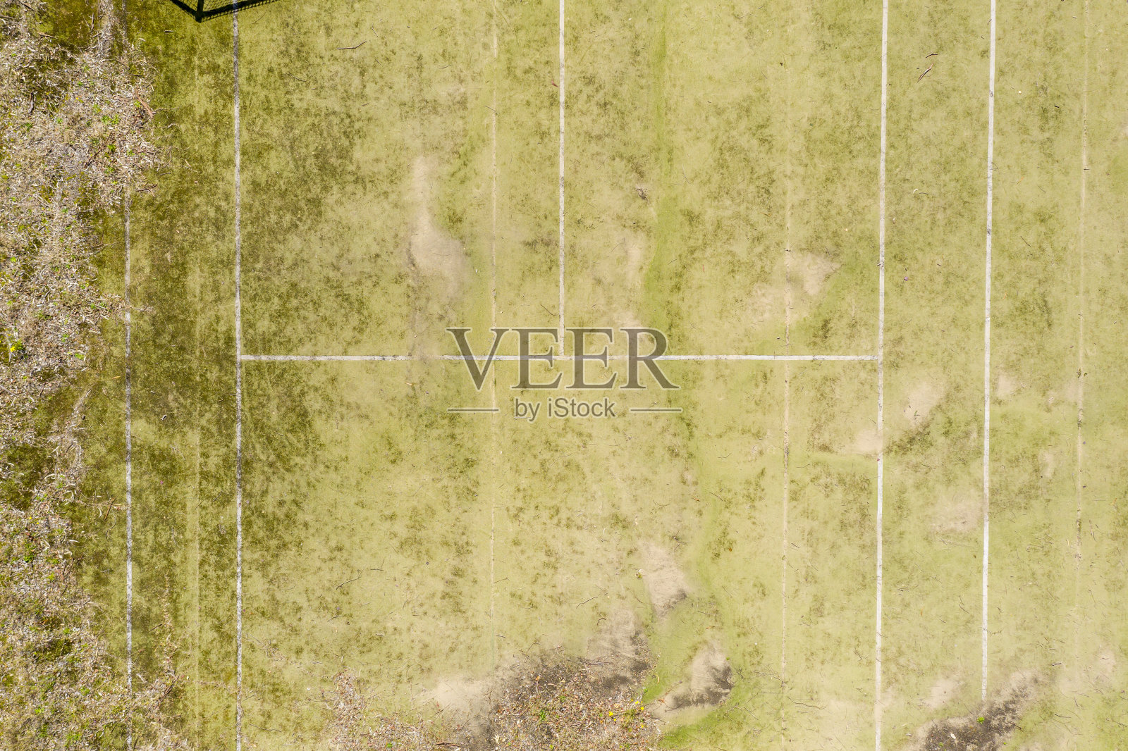 鸟瞰图在一个小区域城镇的一个公园里一个老的废弃网球场年久失修照片摄影图片