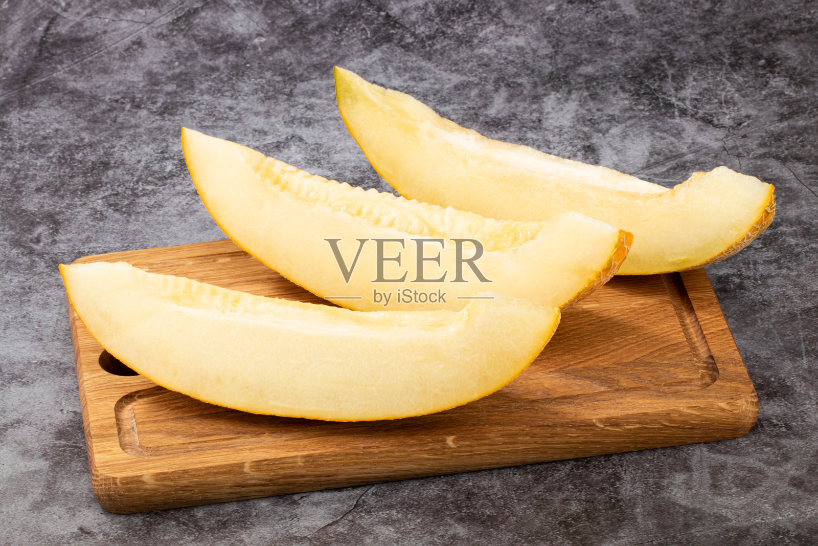 将甜瓜切成片,放在木板上照片摄影图片