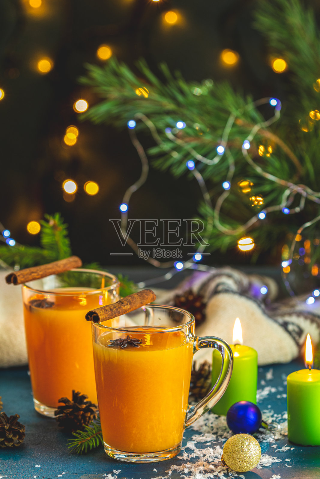 圣诞和新年作文。两杯热辣茶,加入沙棘,肉桂和八角,松树和云杉,蜡烛和节日装饰,散焦照片摄影图片