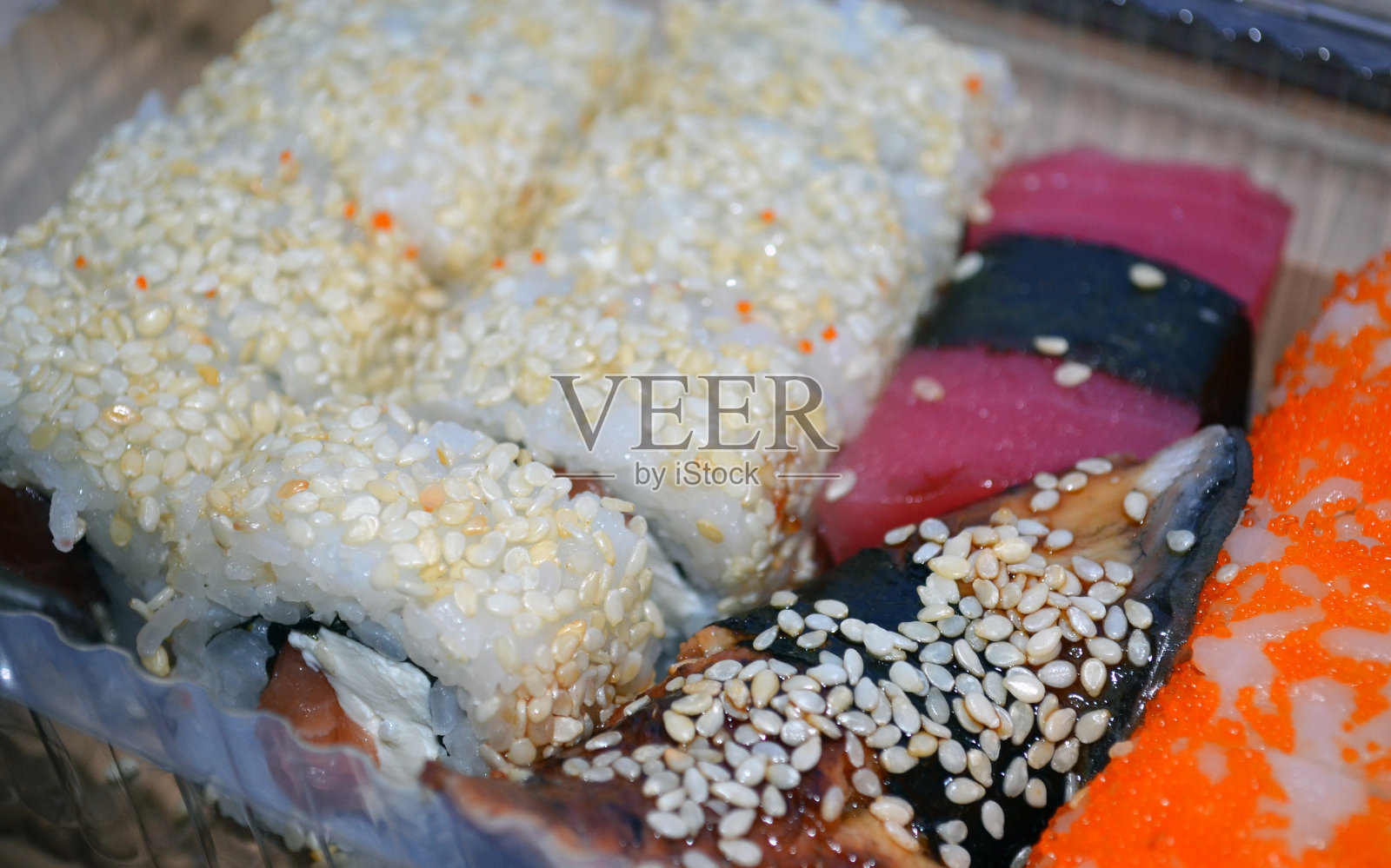 一套寿司,还有鲑鱼和金枪鱼卷。照片摄影图片