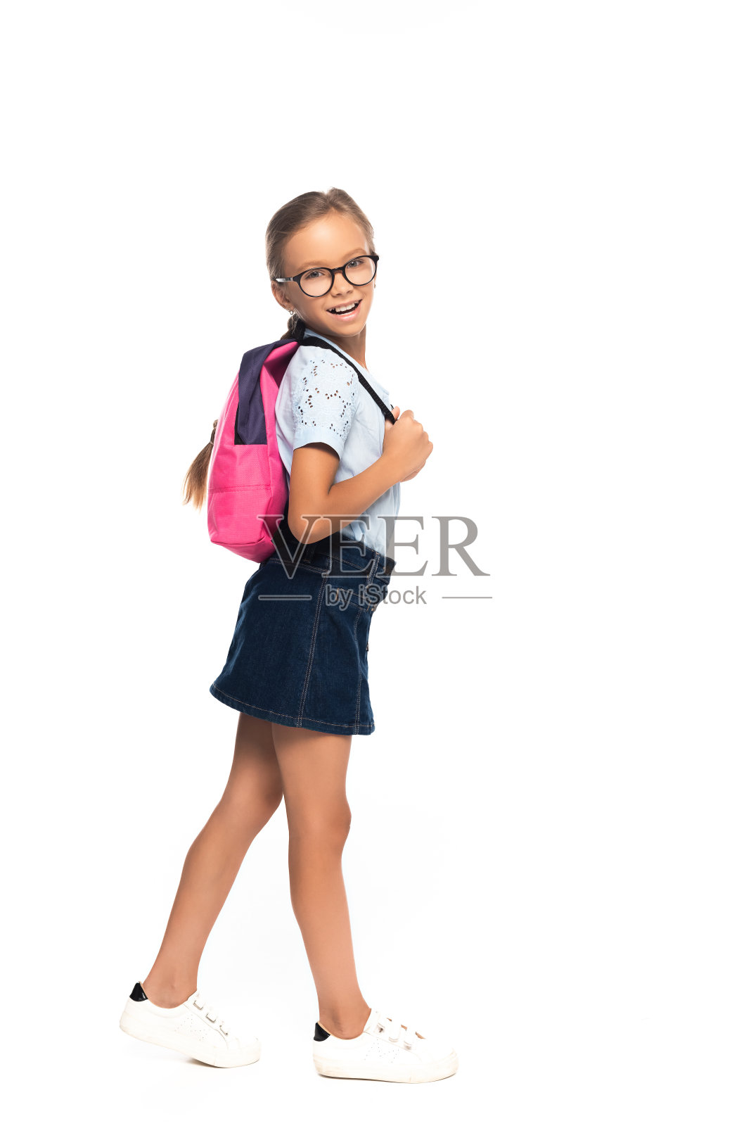 女学生在眼镜站和触摸背包孤立在白色照片摄影图片