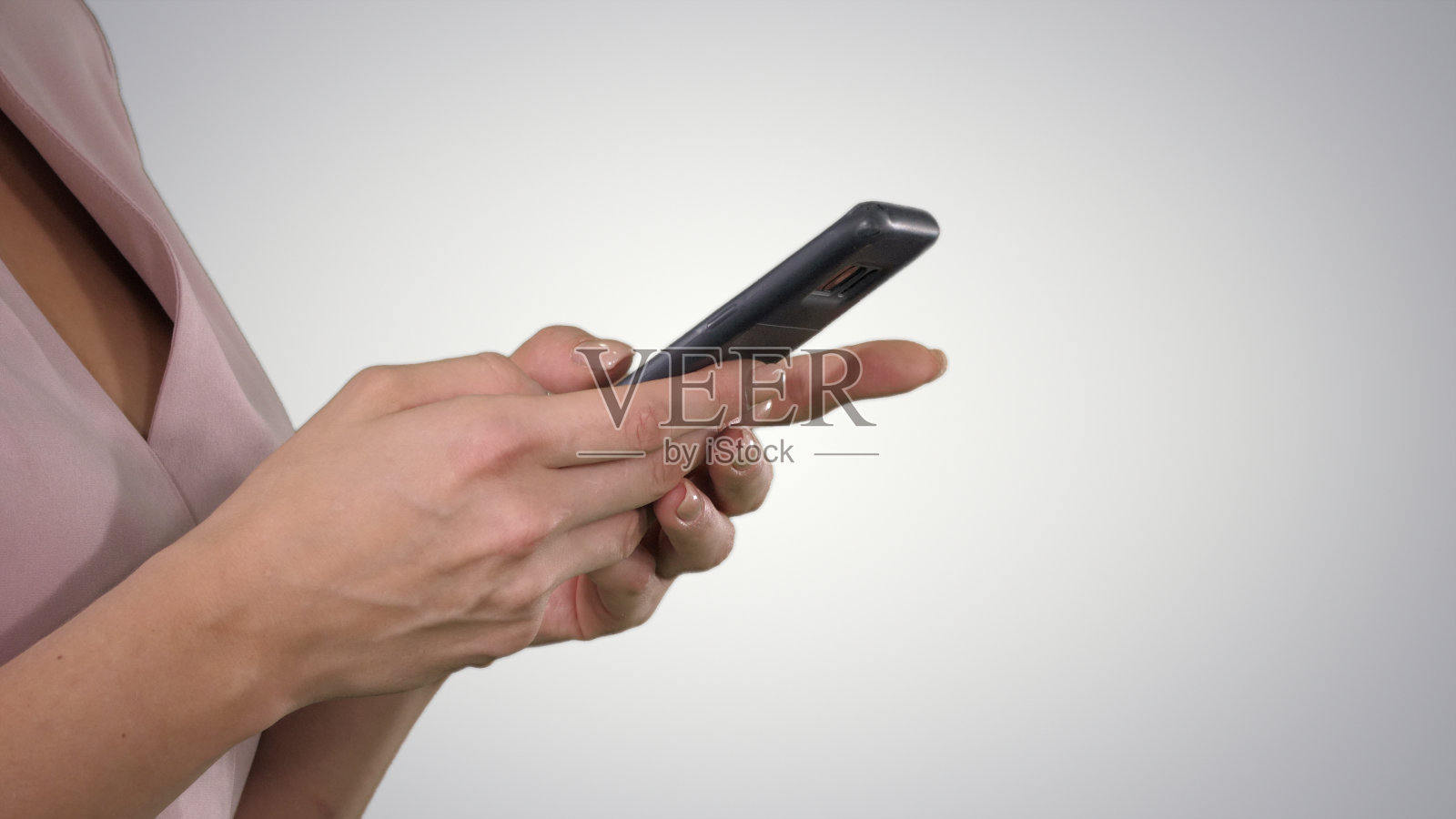 美丽的年轻女人的手使用智能手机在梯度背景照片摄影图片